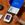 Photo of an Oscar health care kit on a wooden table. There is also a hand holding a thermometer.