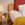 A photo of the Marlow Pillow in use on a bed. Next to the bed is a bedside table with a candle and lamp.